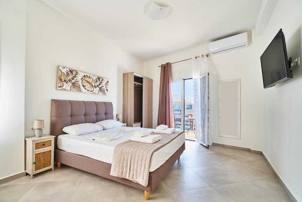 a bedroom with a large bed and a tv at Adele Apartment in Kissamos