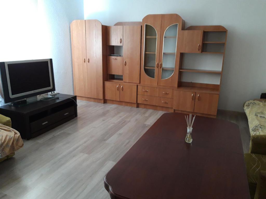 salon z drewnianą szafką i telewizorem w obiekcie Noclegi u Janinki w Ostrowcu Świętokrzyskim