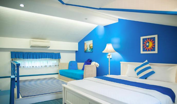 a blue bedroom with a bed and a couch at Spring Villa in Dongshan