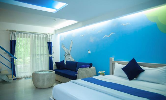 a blue bedroom with a bed and a couch at Spring Villa in Dongshan