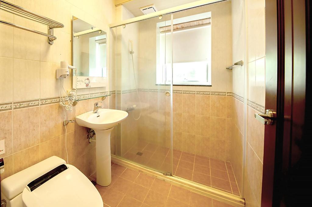 a bathroom with a shower and a toilet and a sink at Spring Villa in Dongshan