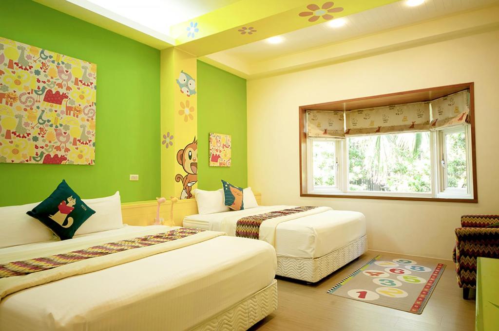 two beds in a room with green walls at Spring Villa in Dongshan