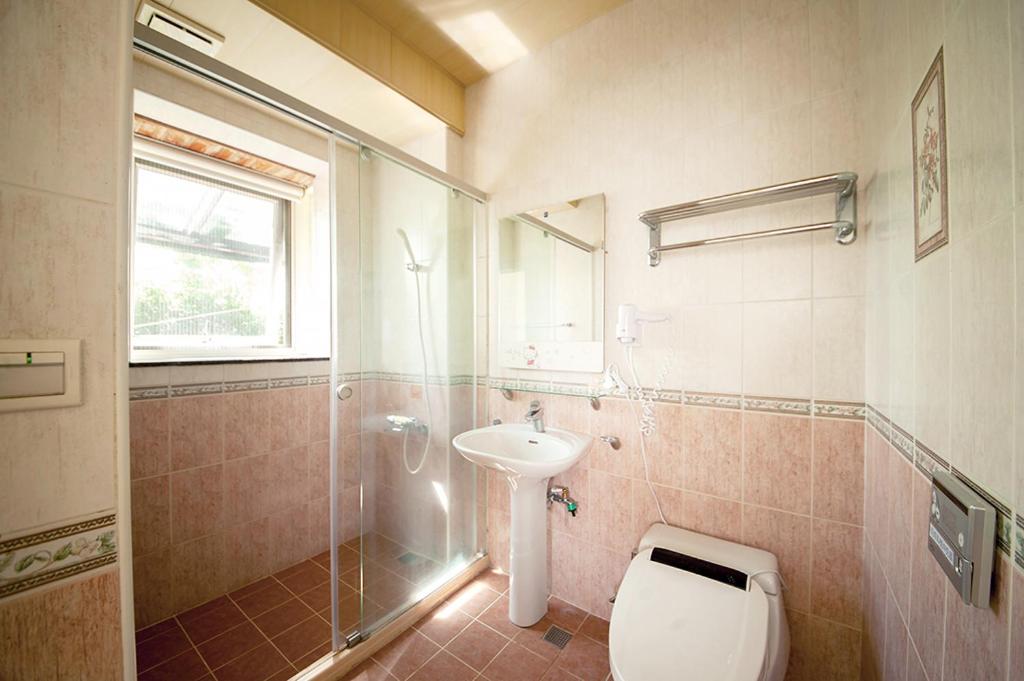a bathroom with a toilet and a sink and a shower at Spring Villa in Dongshan