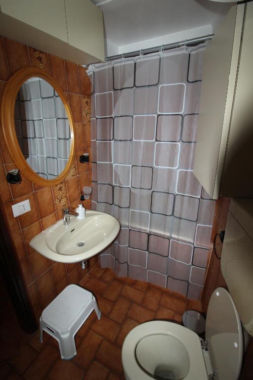 łazienka z umywalką, toaletą i lustrem w obiekcie Casa Rina w mieście Nesso
