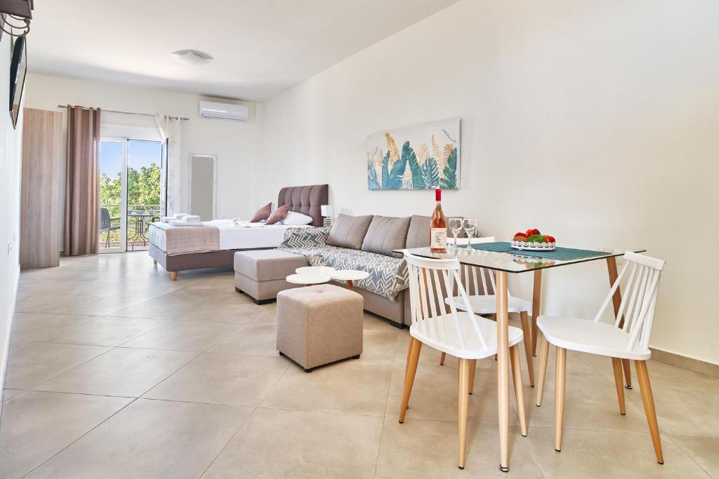 a living room with a couch and a table and chairs at Bella Apartment in Kissamos