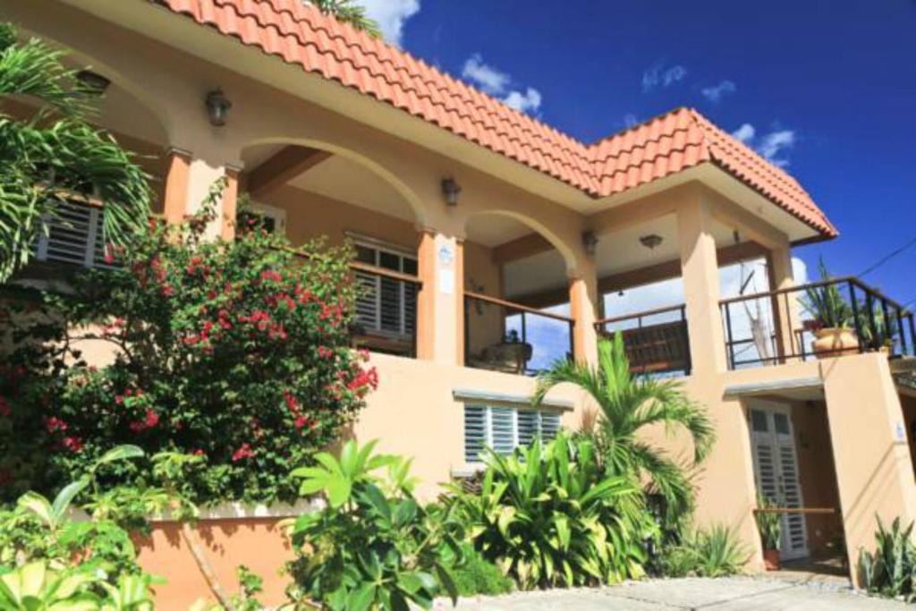 ein großes gelbes Haus mit rotem Dach in der Unterkunft Villa Coral Guesthouse in Vieques