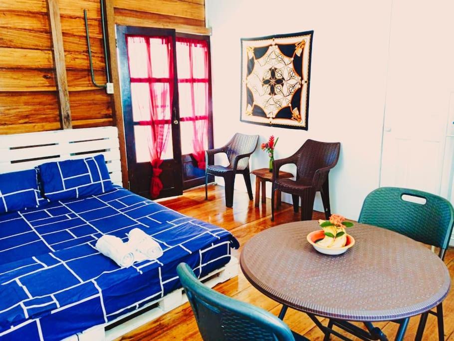 - une chambre avec un lit, une table et des chaises dans l'établissement Poetry Garden Bocas Town Colon Island- Deluxe Bungalow Cabin-AC-Enjoy the Night Life, à Bocas del Toro