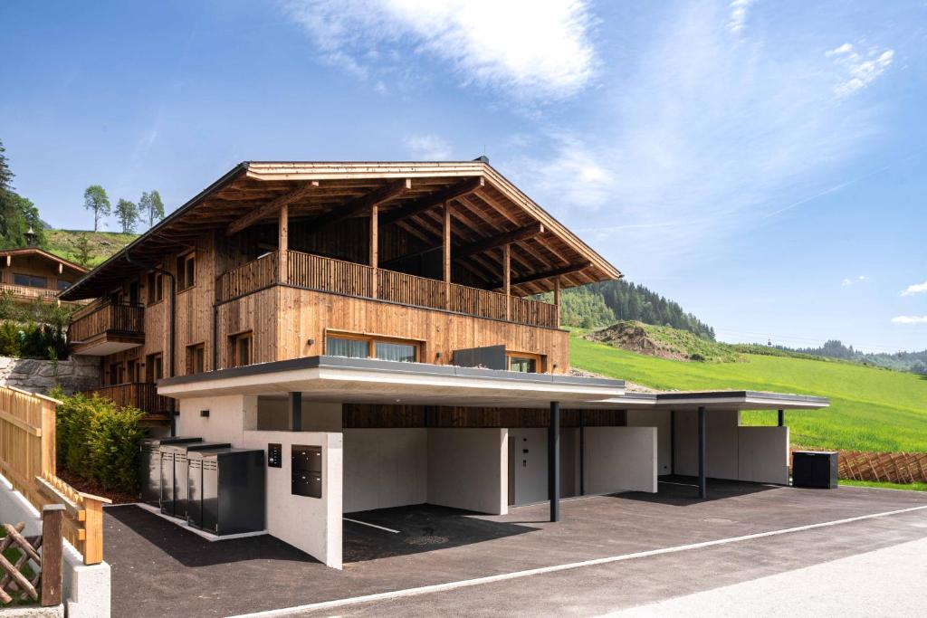 una casa con un gran edificio con una colina en el fondo en Hohe Tauern Lofts Panoramabahn by Alpina-Holiday, en Dorf