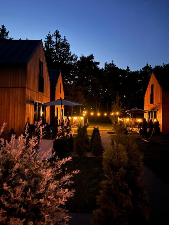 a group of people sitting in a yard at night at MikroKlimat in Jarosławiec