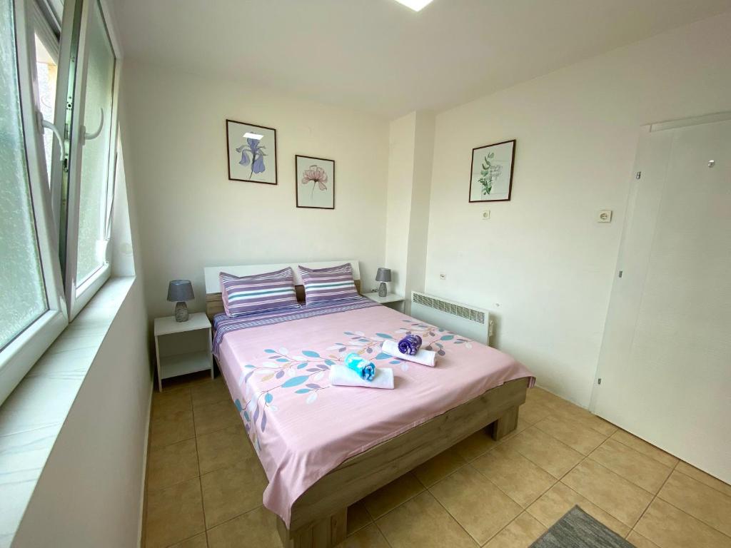 a bedroom with a bed with pink sheets and stuffed animals on it at Central DELUXE Apartment in Prilep