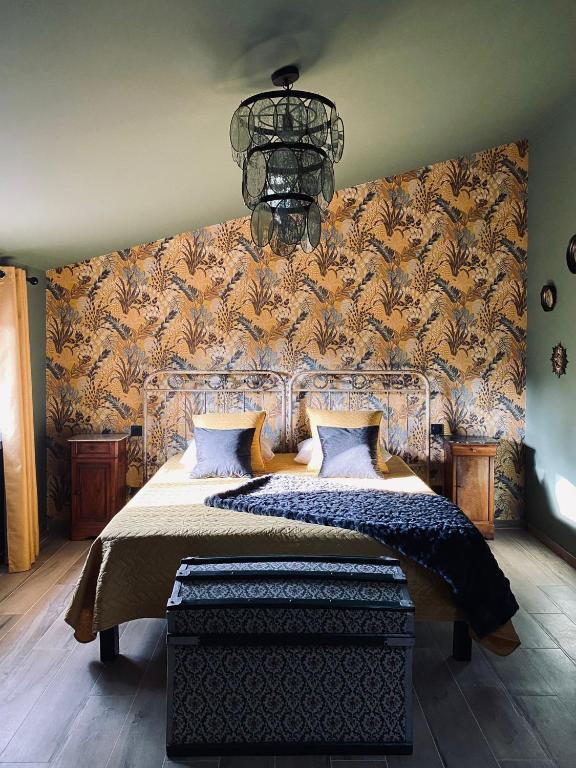 a bedroom with a large bed and a chandelier at Sous Les Pins gîtes et chambres d'hôtes in La Londe-les-Maures