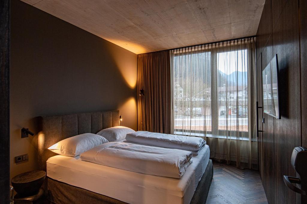 um quarto com uma cama e uma grande janela em Lifestyle B&B by Phillip Sigwart em Brixlegg