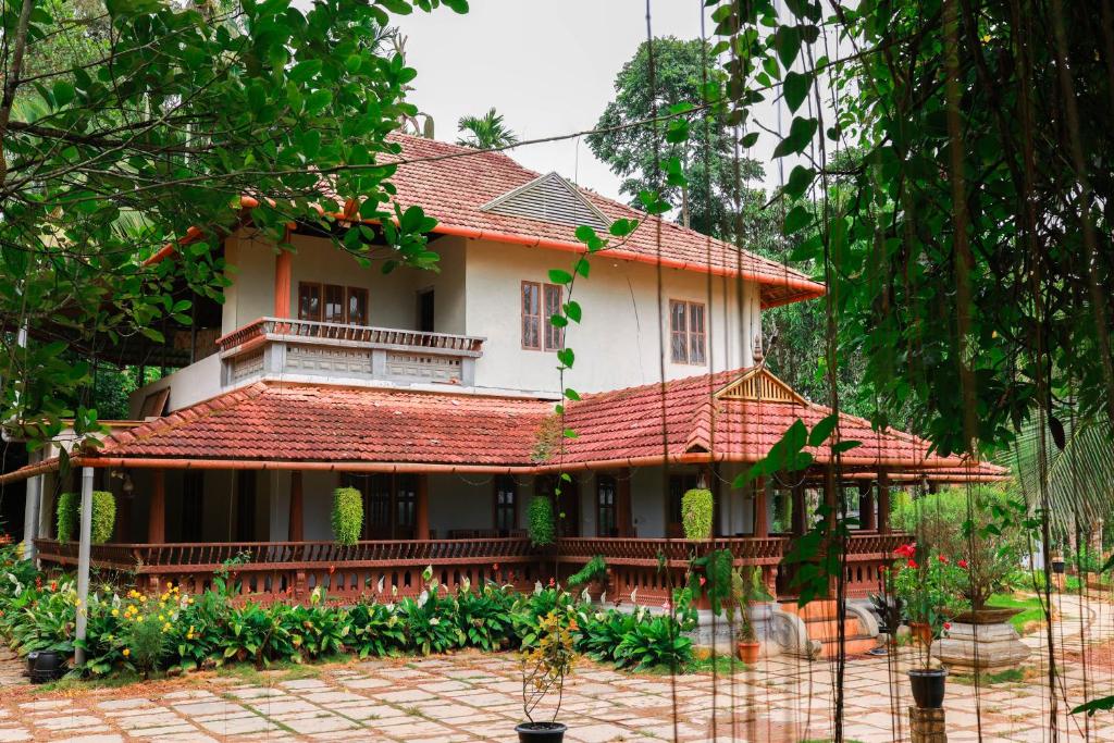 a house with a red roof at Wayal Wayanad Farm Resort in Panamaram