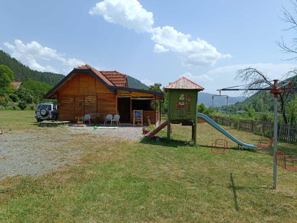 ein Blockhaus mit Rutsche und Spielplatz in der Unterkunft Drinski dragulj in Višegrad