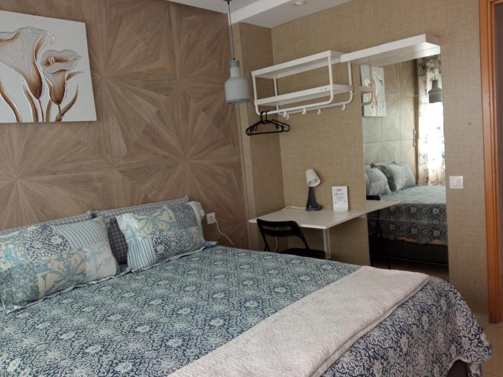 a bedroom with a bed and a desk and a mirror at Agréable appartement in Rabat