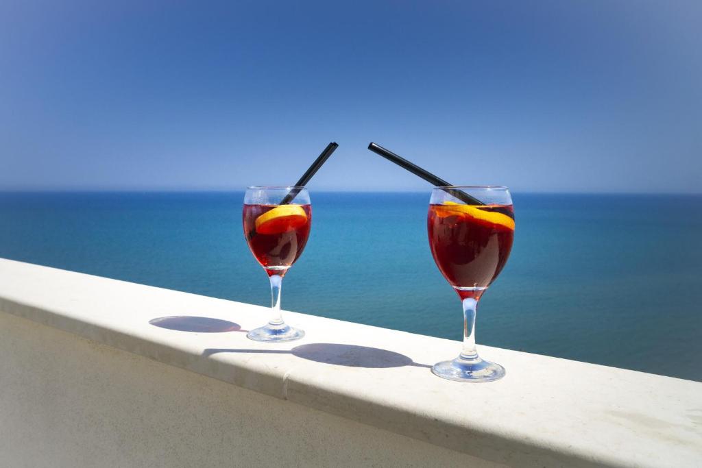 two glasses of wine on a ledge overlooking the ocean at Terrazza Grecale in Rodi Garganico