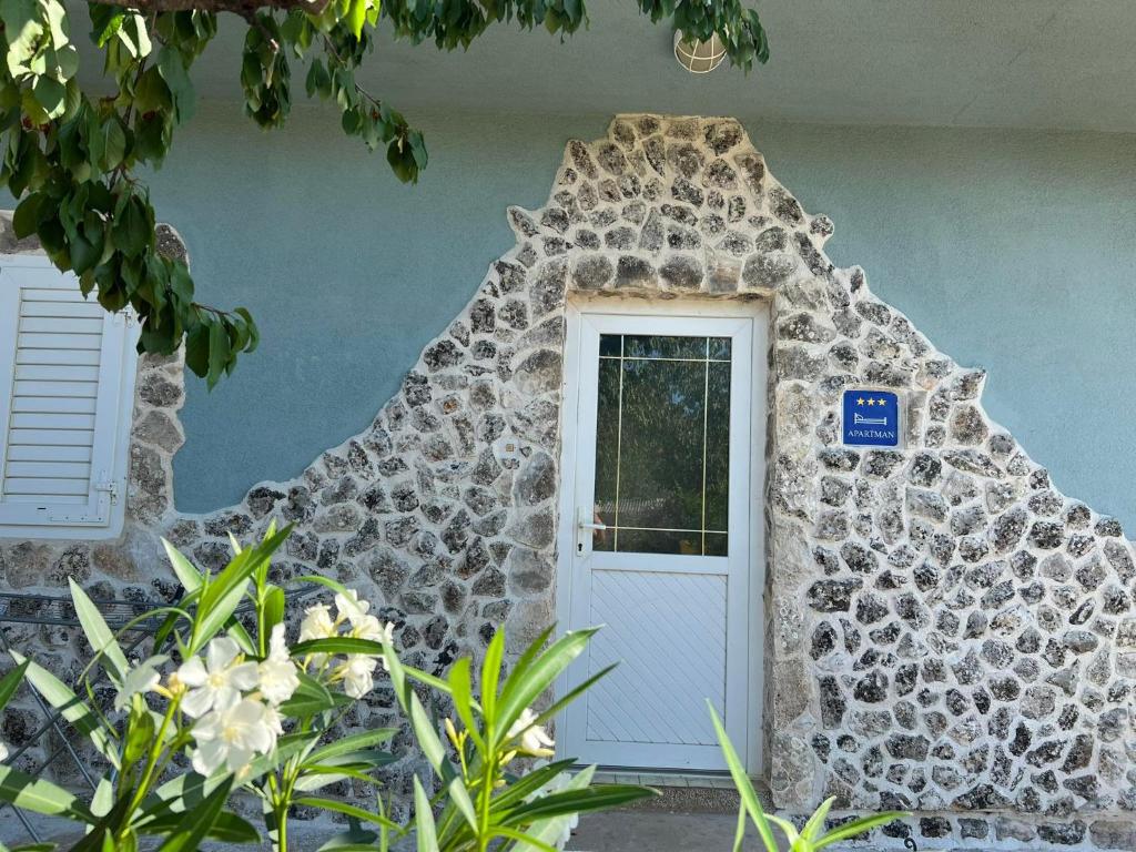 una puerta delantera de una casa con una pared de roca en Kod Škilje, en Šibenik