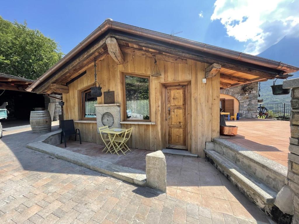 Cabaña de madera pequeña con puerta y patio en profumo di legno, en Aosta