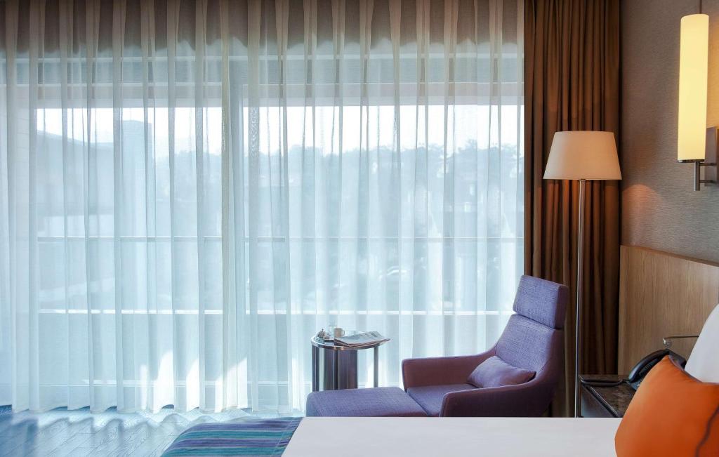 a bedroom with a bed and a chair and a window at Radisson Blu Hotel & Spa, Istanbul Tuzla in Istanbul