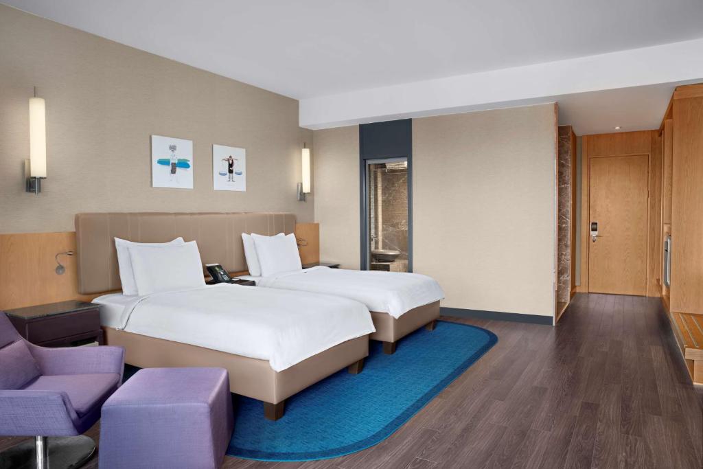 a hotel room with two beds and a couch at Radisson Blu Hotel & Spa, Istanbul Tuzla in Istanbul