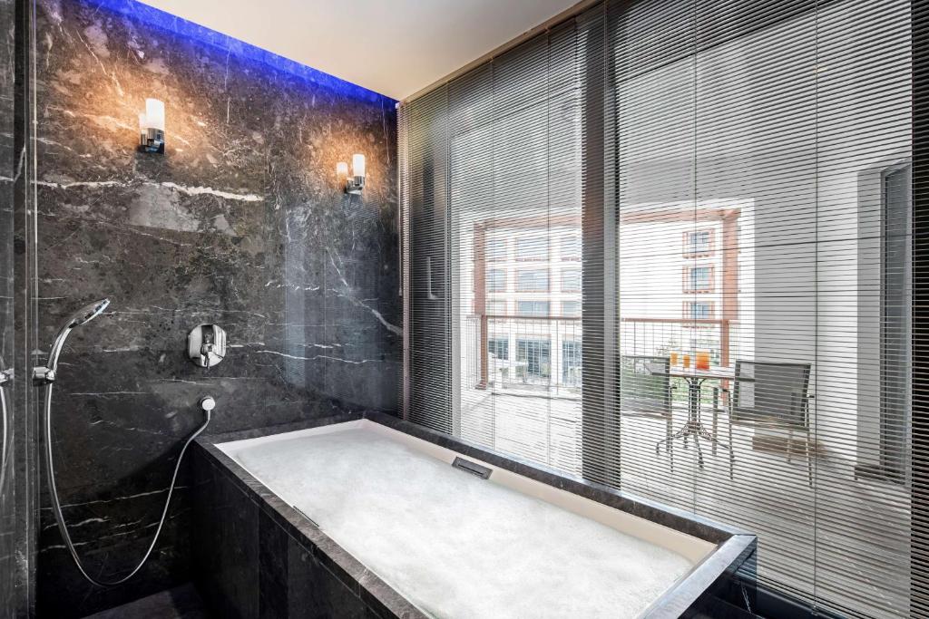 a bathroom with a large tub and a window at Radisson Blu Hotel & Spa, Istanbul Tuzla in Istanbul