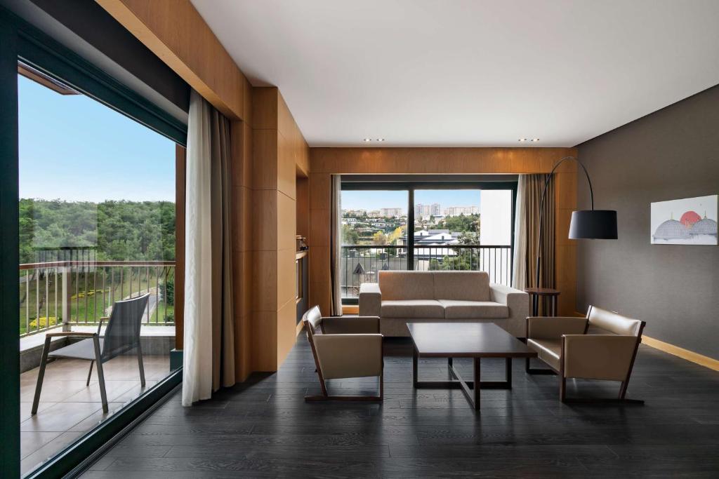 a living room with a couch and a table and chairs at Radisson Blu Hotel & Spa, Istanbul Tuzla in Istanbul