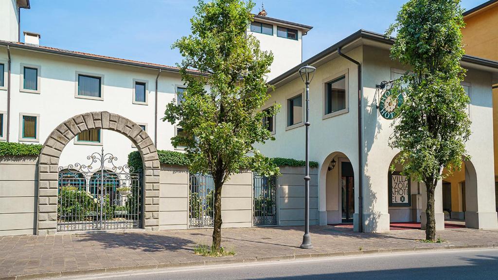 un edificio con una puerta y árboles delante de él en Hotel Villa Zoia, en Boltiere