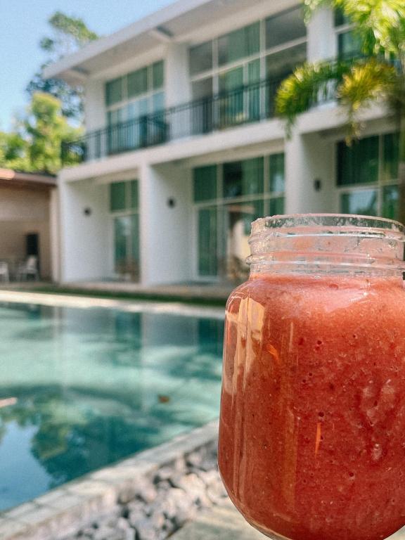 a jar of liquid sitting next to a swimming pool at Green Hill Mirissa in Mirissa