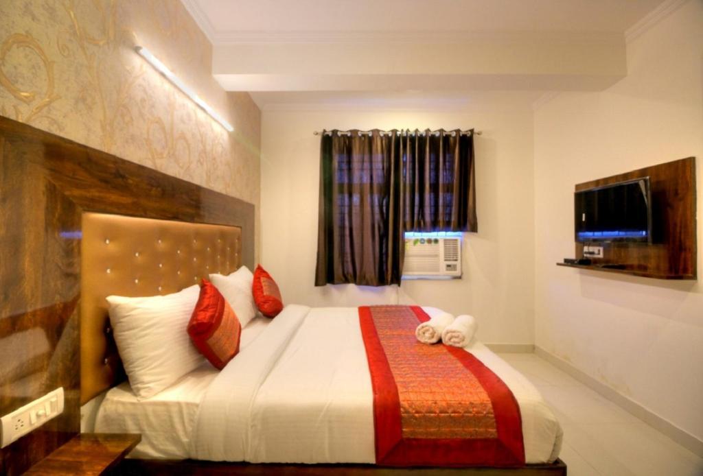 a bedroom with a bed and a television in it at Ark of Avalon Near IGI AirPort New Delhi in New Delhi