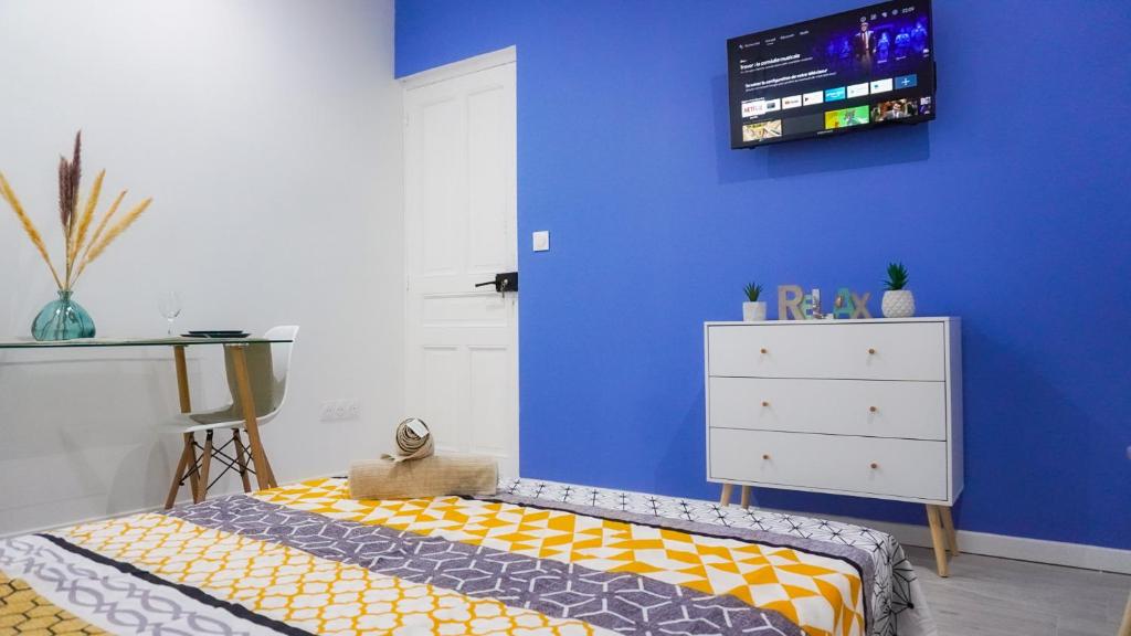 - une chambre avec un lit et un mur bleu dans l'établissement AppartCosy-StQuentin, à Saint-Quentin
