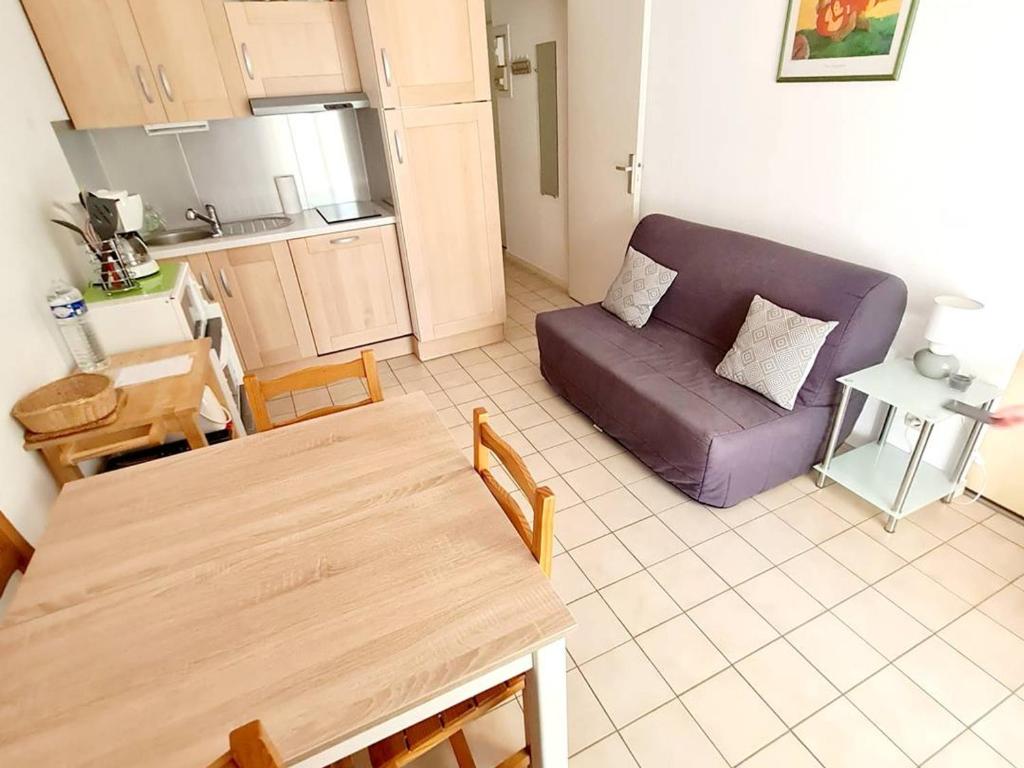 sala de estar con sofá púrpura y mesa en Appartement Six-Fours-les-Plages, 2 pièces, 4 personnes - FR-1-316-21, en Six-Fours-les-Plages