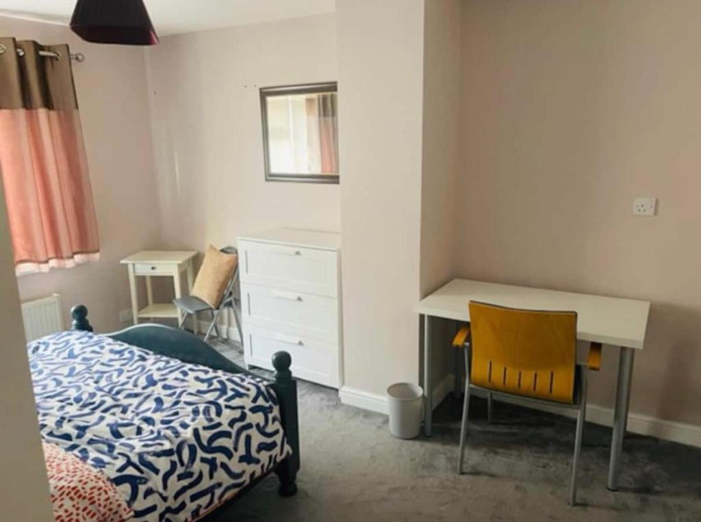 a bedroom with a bed and a desk and a table at Mia Property in Bristol