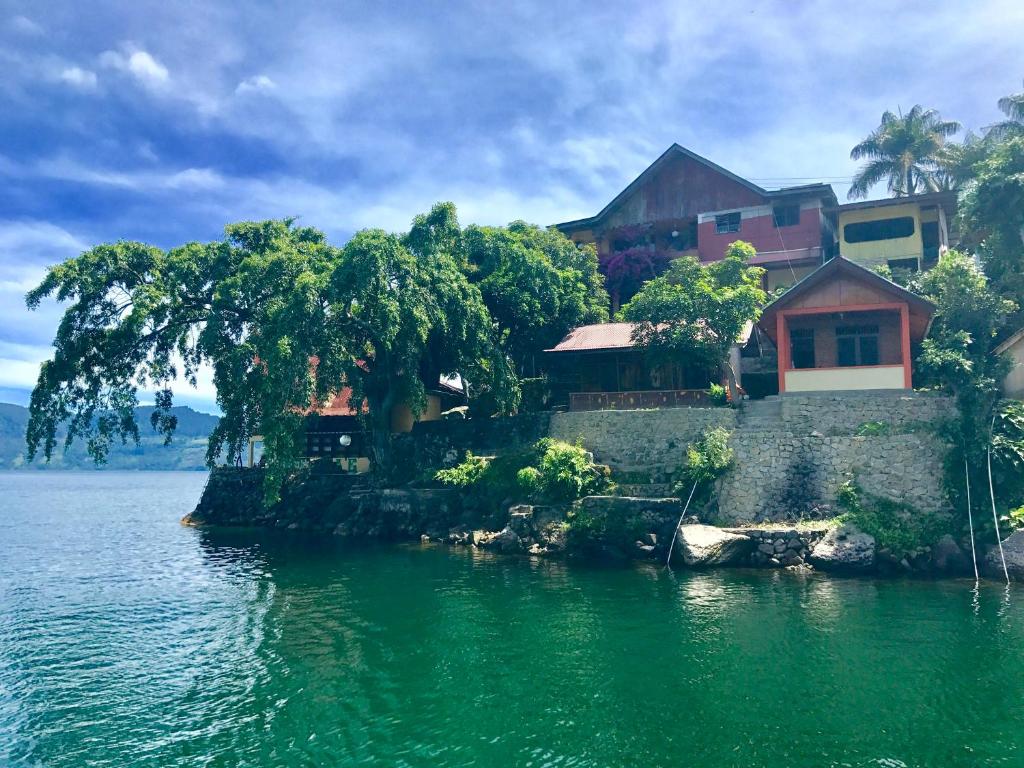 a house on a island in the water at Reggae Guest House in Tuk Tuk