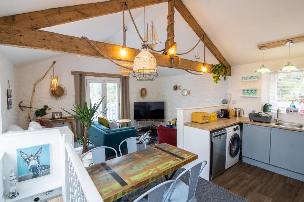 a kitchen and living room with a table and a dining room at Cozy, Chic, Dairy Cottage near to Beach & Shops- Parking in Torquay
