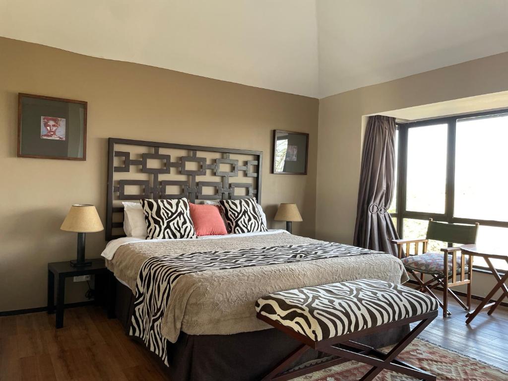 a bedroom with a large bed with a zebra patterned headboard at Nyikani Villa Olpejeta in Nanyuki