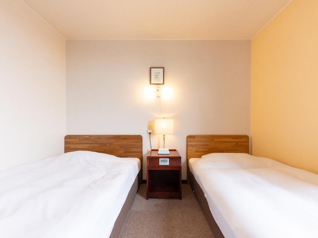Postel nebo postele na pokoji v ubytování Tabist Travel Inn Shinshu Nakano