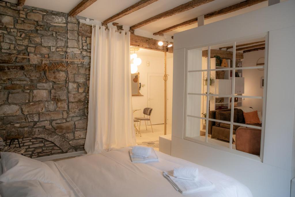 a bedroom with a bed and a stone wall at Rosalia Apartment in Koper