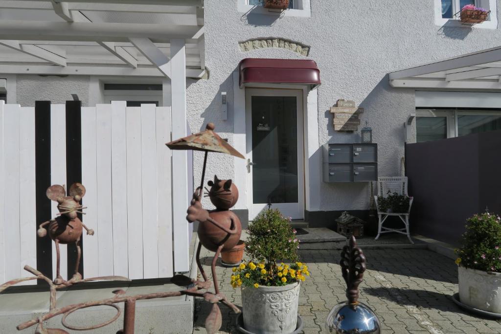 una casa con una valla blanca y un patio en L'Union B&B - Chambres d'hôtes, en Tramelan