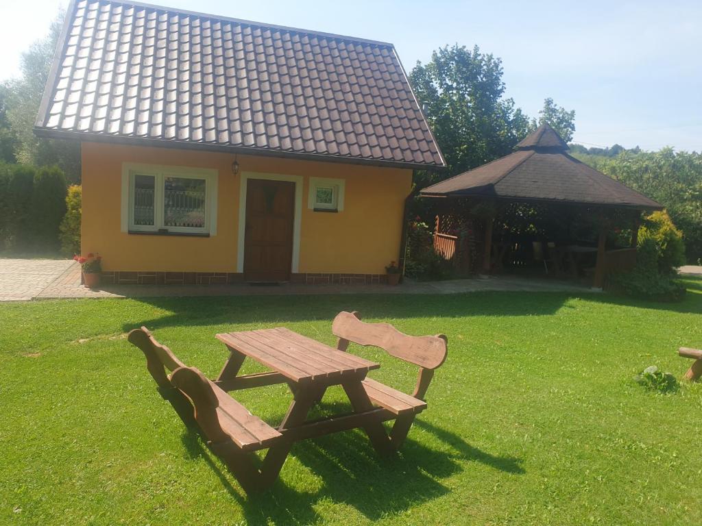 a picnic table and two chairs in front of a house at Domek u Ani in Orelec