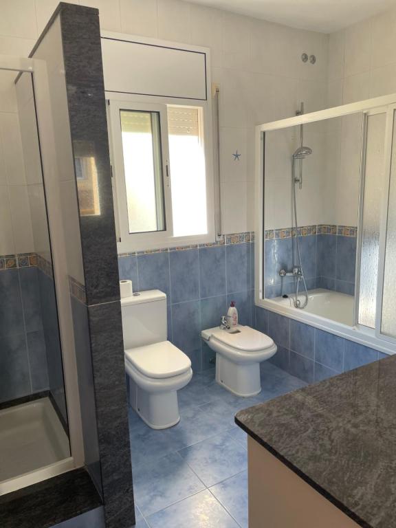 a bathroom with two toilets and a tub and a sink at Willa con piscina in El Vendrell