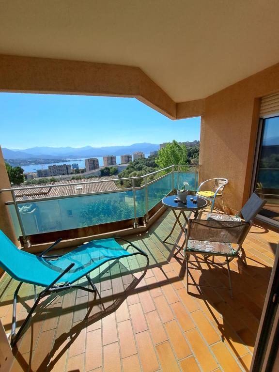 een balkon met een zwembad en een tafel en stoelen bij appartement vue mer avec parking in Ajaccio