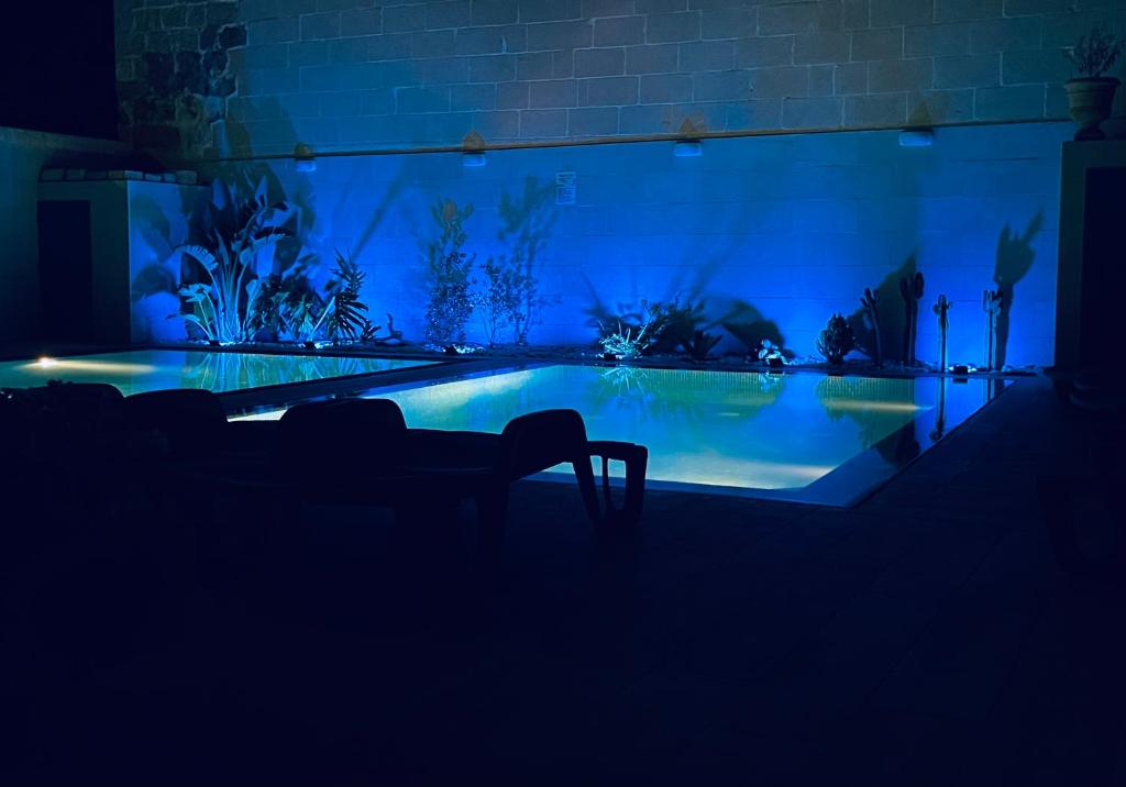 a dark room with a swimming pool at night at Fiftyfour West Boutique Living in Għarb