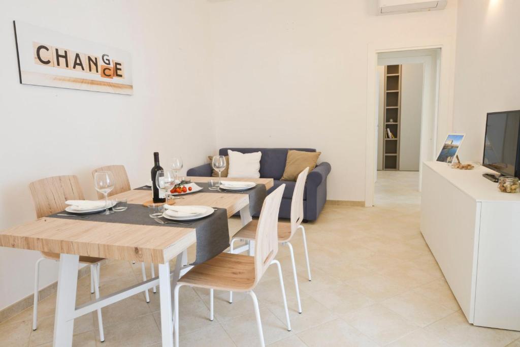 a living room with a dining table and a couch at Blue Sea Villas by Wonderful Italy in Ostuni