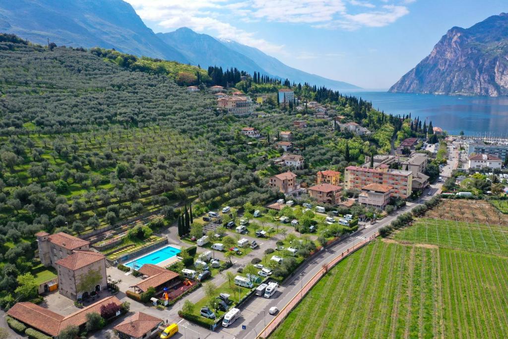 an aerial view of a villa with a resort and a lake at Camping Brione in Riva del Garda