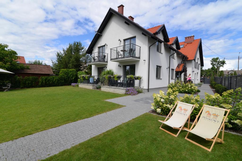 a house with two lawn chairs in the yard at Piaskowy 2 in Jantar