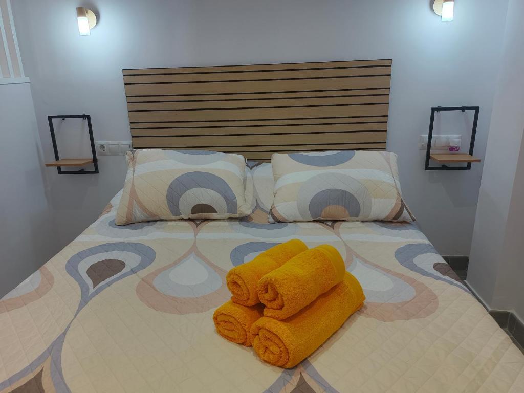 ein Bett mit zwei Handtüchern darüber in der Unterkunft Rentaly Holidays Apartamento Artes de Arcos Almería in Almería