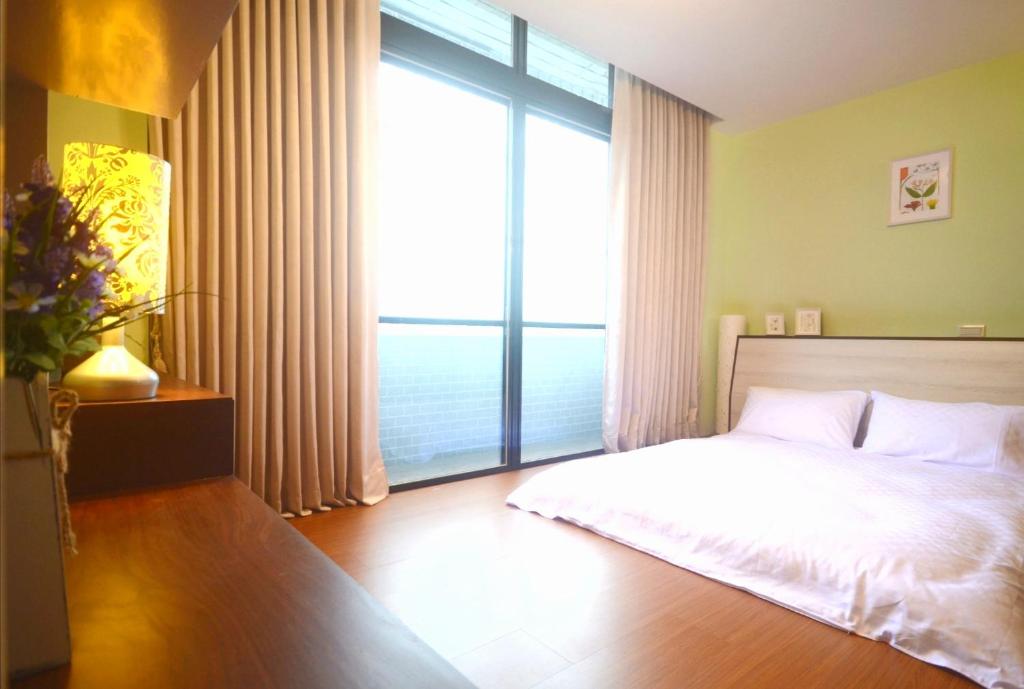 1 dormitorio con cama y ventana grande en Xinshe Xiao Shu time homestay, en Xinshe