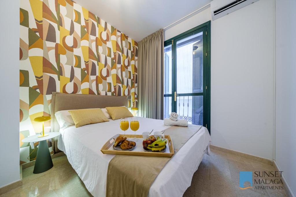 a bedroom with a tray of food on a bed at MALAGA CENTRAL SUITES - New Release in Málaga