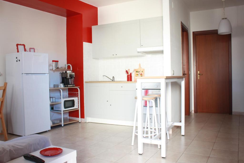 uma cozinha com armários brancos e um frigorífico branco em Fiore di Piesco-b&b di charme em Satriano di Lucania