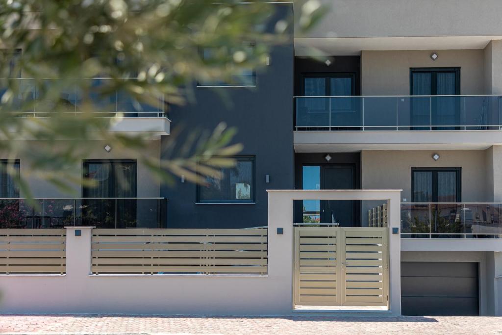 a building with a wooden fence in front of it at Anais Apartments in Korinós